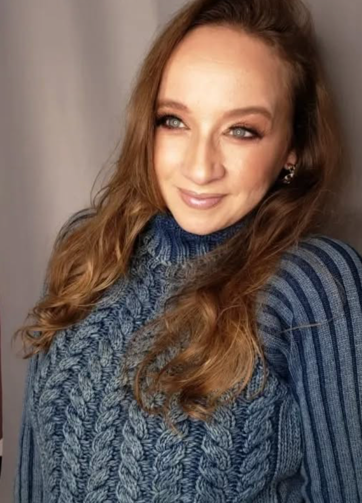Renata Marcolino com suéter azul, expressão calorosa